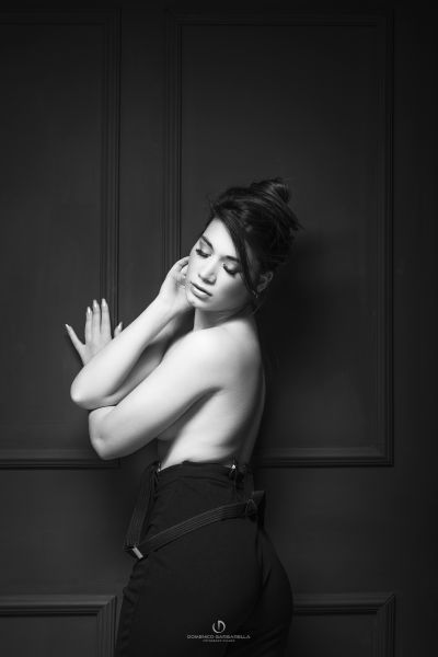 ritratto boudoir glamour in bianco e nero BW ragazza topless appoggiata parete stile vittoriana