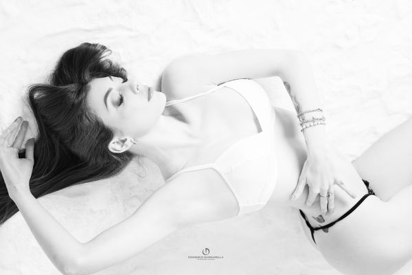 Ritratto Boudoir con una donna sdraiata su un letto in lingerie